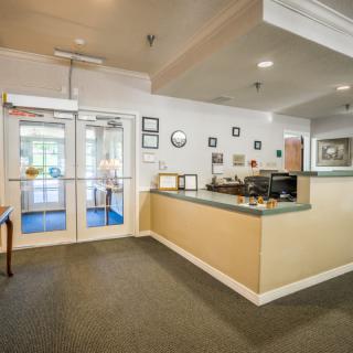 A clean and welcoming hotel lobby with a reception desk and entrance doors.