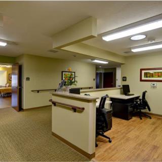 A reception area with a desk and chairs in an office setting.
