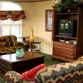 A vintage-style living room with patterned couches and an old-fashioned television set.