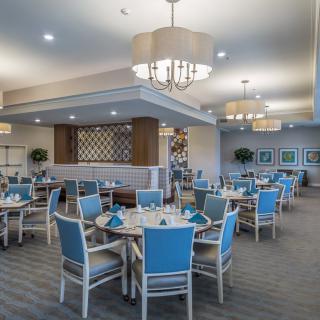 A modern dining area with blue-accented decor and elegant chandeliers.