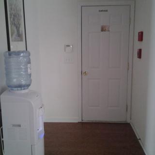 A hallway with a water cooler and a closed door.