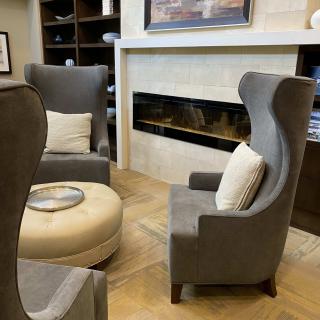 A modern living room with comfortable chairs and a fireplace.