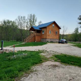 A charming wooden cabin set in a serene natural landscape.