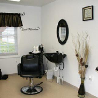 A cozy hair salon interior with a styling chair, mirror, and washbasin.