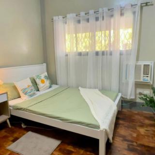 A cozy, modern bedroom with a neatly made bed and soft lighting.