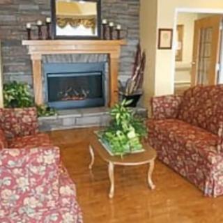 A cozy living room featuring a fireplace, floral-patterned sofas, and a wooden coffee table.