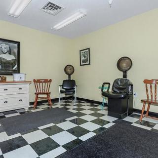 A retro-style barbershop interior with checkered flooring and vintage decor.