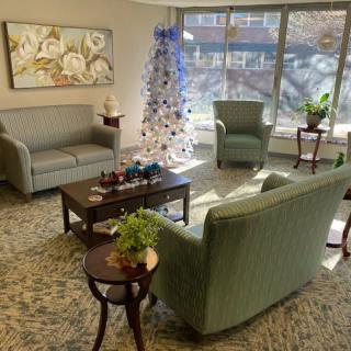 A cozy living room decorated with a Christmas tree and comfortable seating.