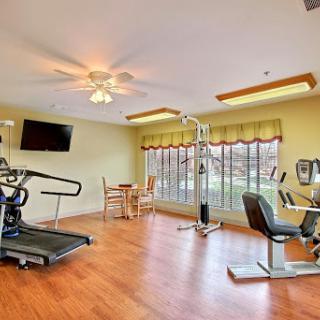 A well-lit gym area featuring various fitness equipment, perfect for indoor workouts.