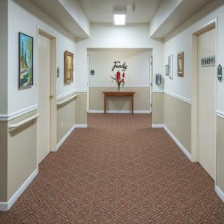 A quiet hallway with artwork on the walls, decorated with a table and flowers.