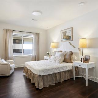 A cozy and modern bedroom with a comfortable bed, stylish lamps, and a large window letting in natural light.