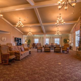 A spacious and elegantly decorated lounge with multiple seating areas and chandeliers.