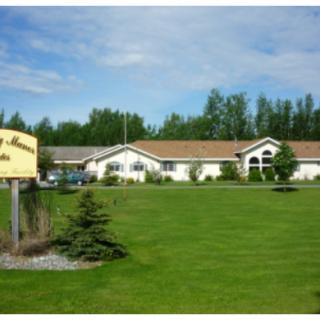 A building with a well-maintained lawn and a sign on a clear day.