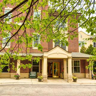 A view of a brick building entrance surrounded by trees.