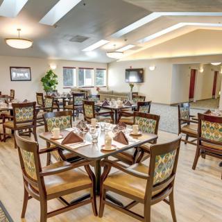 A well-lit dining area with modern decor, featuring neatly arranged tables and chairs.
