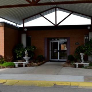Entrance to a building with plants and an awning overhead.