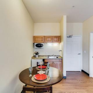 A compact kitchen area with a small dining table set for two in an apartment.