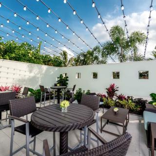 An inviting outdoor patio with seating and string lights under a clear sky.