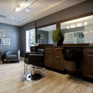 A modern and stylish hair salon interior with comfortable chairs, large mirrors, and sleek styling stations.