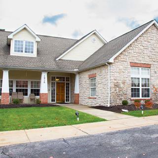 A suburban residential house with a manicured lawn and driveway.