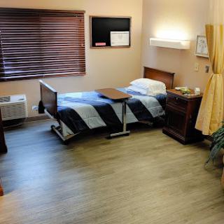 A clean and simple hospital room, featuring a bed and minimal furniture.