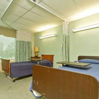 A hospital room with two beds and a partition curtain.