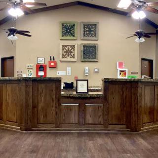 A reception area with a wooden desk and decorative artwork on the wall.