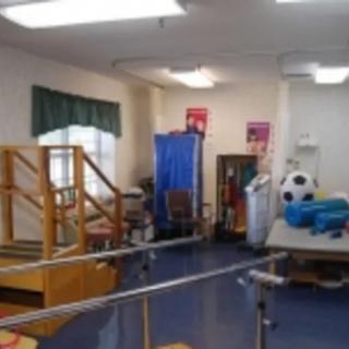 A physical therapy room with various exercise equipment and rehabilitation tools.