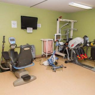 A small exercise room with various fitness equipment, including stationary bikes and a treadmill.
