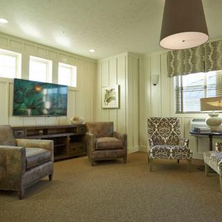 A cozy living room with modern furniture and a large television.