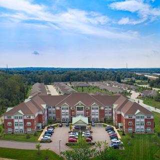 Aerial view of a large residential building with a surrounding suburban landscape.