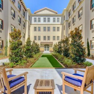 A beautifully landscaped courtyard with outdoor seating nestled between residential buildings.