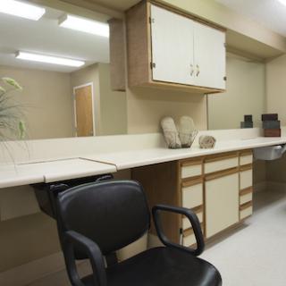 A clean and organized workspace featuring a chair and counter with storage.