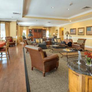 A spacious and elegantly furnished living room with comfortable seating and warm decor.