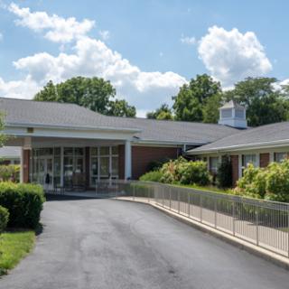 A welcoming entrance to a well-maintained building surrounded by lush greenery.