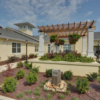 A well-maintained garden with a pergola and building exterior.