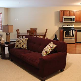 A cozy living room area with a comfortable sofa and an integrated kitchen.