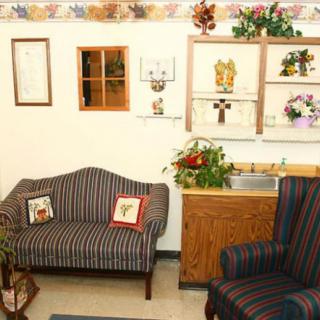 A cozy living room with a striped sofa and armchair, adorned with wall art and plants.