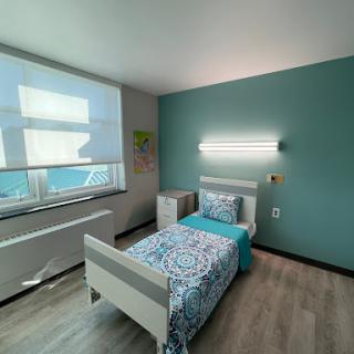 A cozy modern bedroom featuring a single bed, a soothing color palette, and ample natural light.