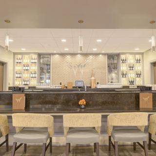 A modern hotel lobby with a stylish reception desk and comfortable seating area.