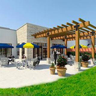 Outdoor patio area with seating and a wooden pergola on a sunny day.