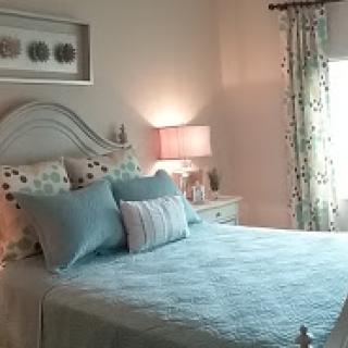 A beautifully designed bedroom featuring a cozy bed with decorative pillows and soft lighting.