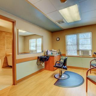 A brightly lit salon interior featuring a barber chair and mirror.