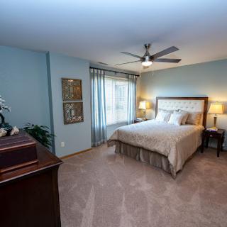 A cozy and elegantly furnished bedroom with soft lighting and a serene color palette.
