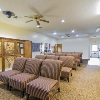 A spacious waiting room with arranged seating and a ceiling fan.