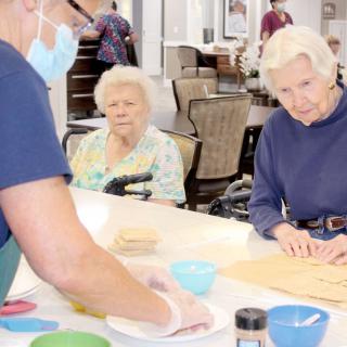 Elderly residents participating in a cooking activity at a care home.