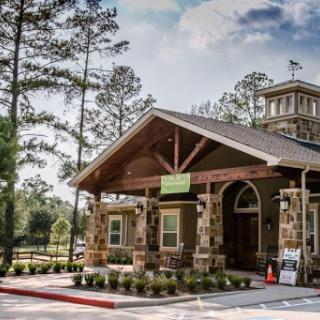 A charming community center set amidst tall trees, featuring a rustic wooden design.