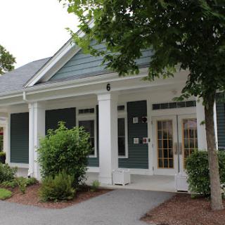 A charming single-story house with a welcoming porch and well-maintained landscaping.