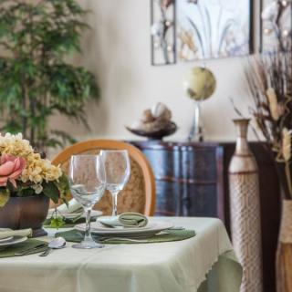 An elegantly set dining table with decorative flowers and glassware in a stylishly decorated room.