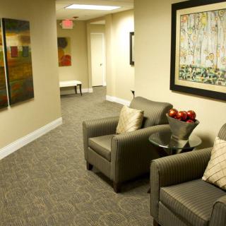 A modern lobby with comfortable armchairs and decorative paintings on the wall.